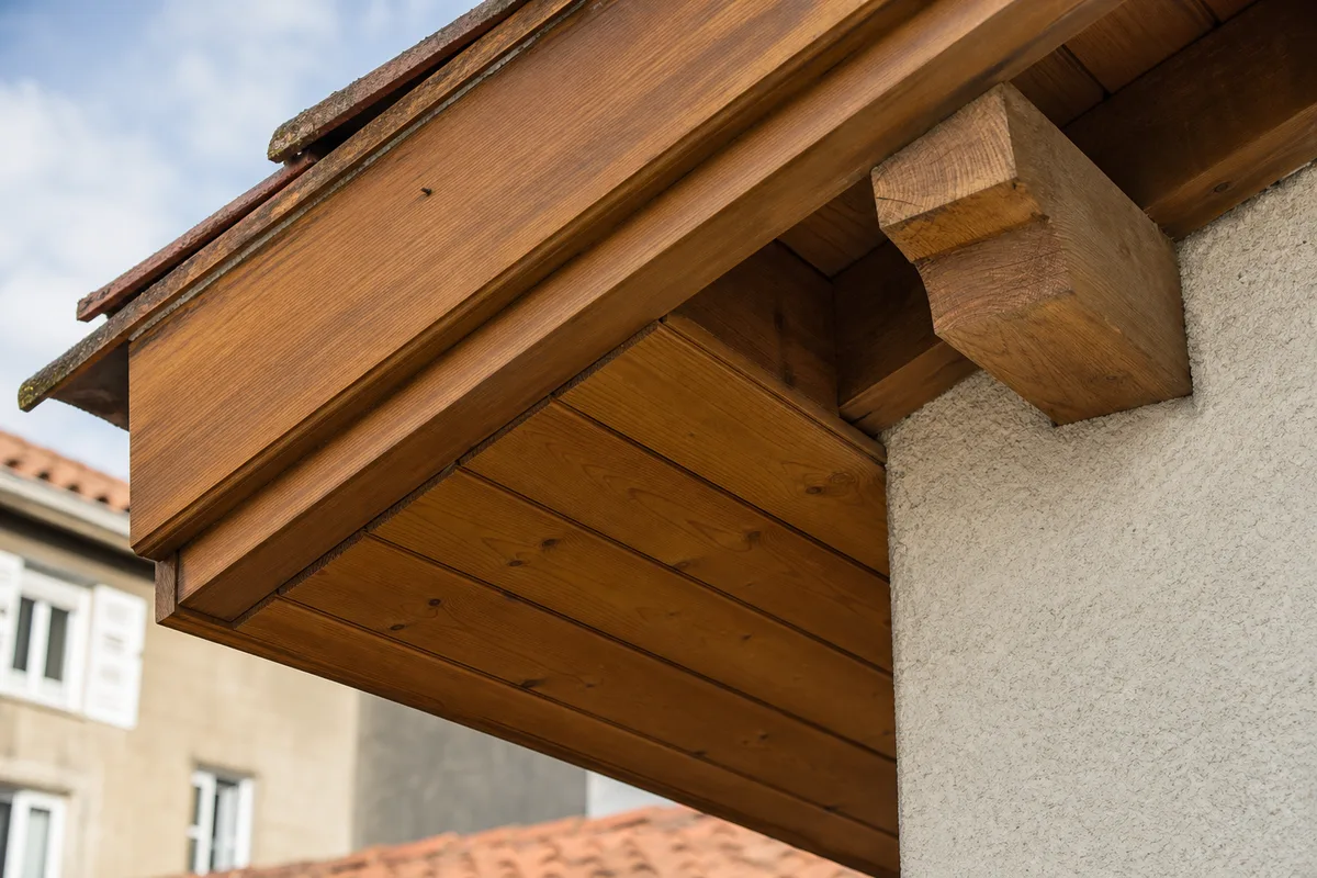 Sous-face de toiture habillée en frisette bois sous un débord de toit d&rsquo;une maison de bourg ligérienne
