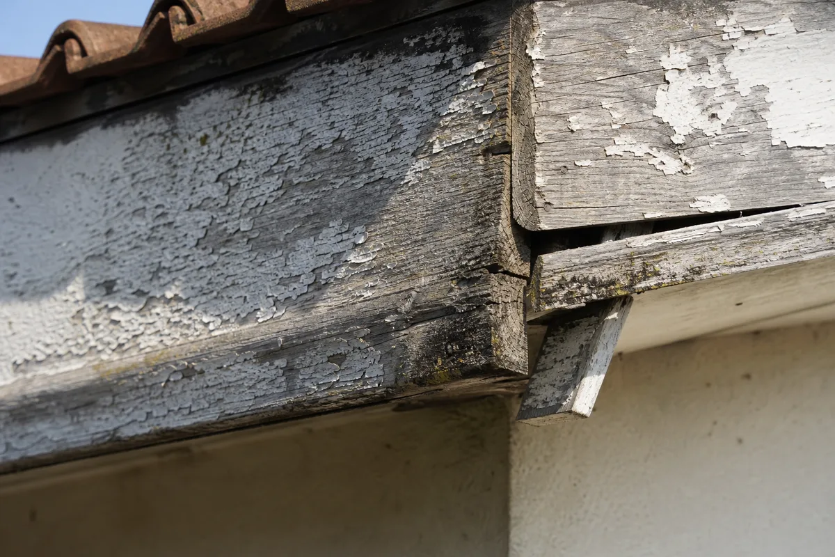Bandeau de toiture en bois peint dégradé sur un pavillon des années 70
